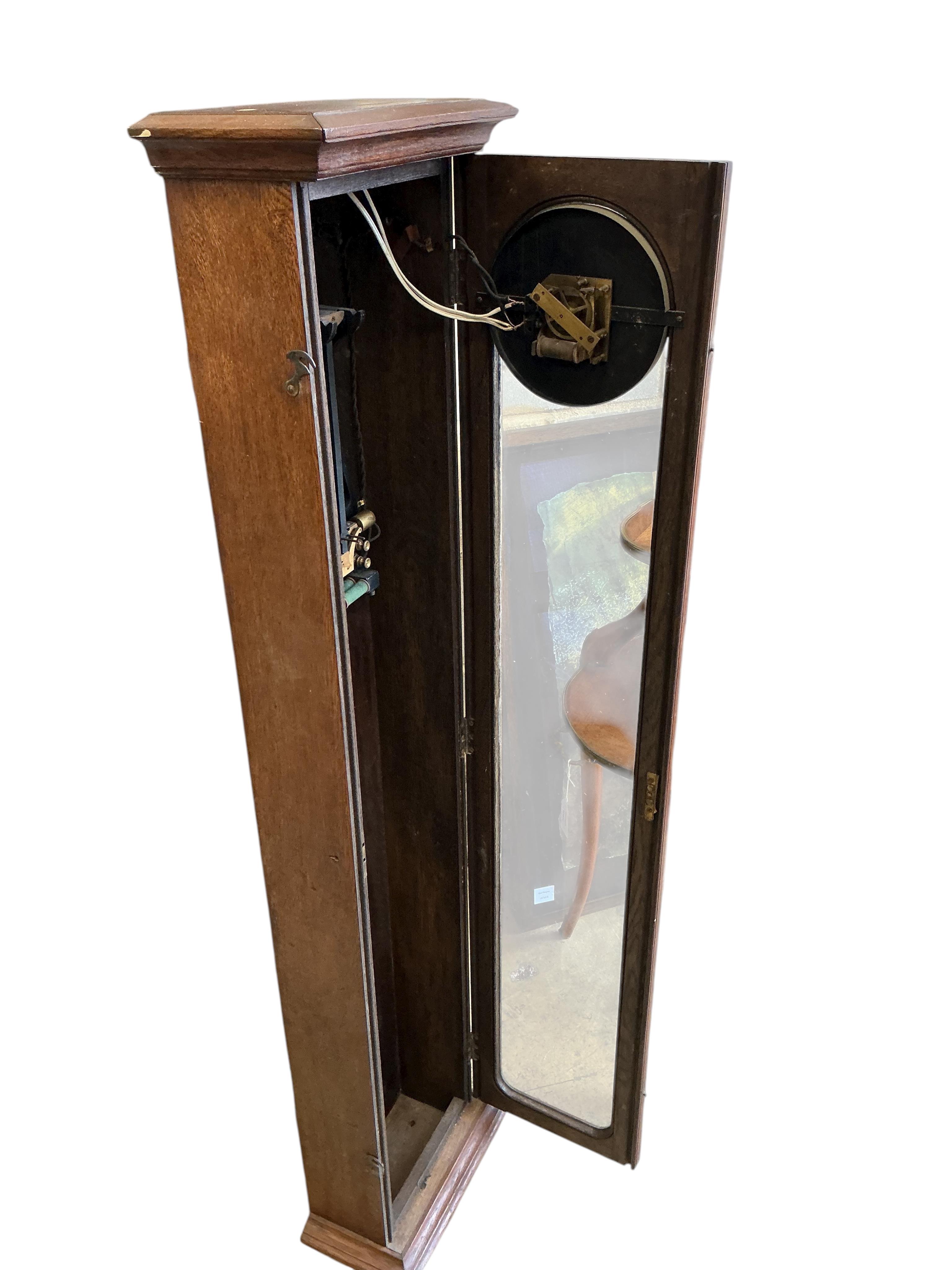 A Gillett & Johnston oak cased electric Master wall clock, with pendulum, height 139cm